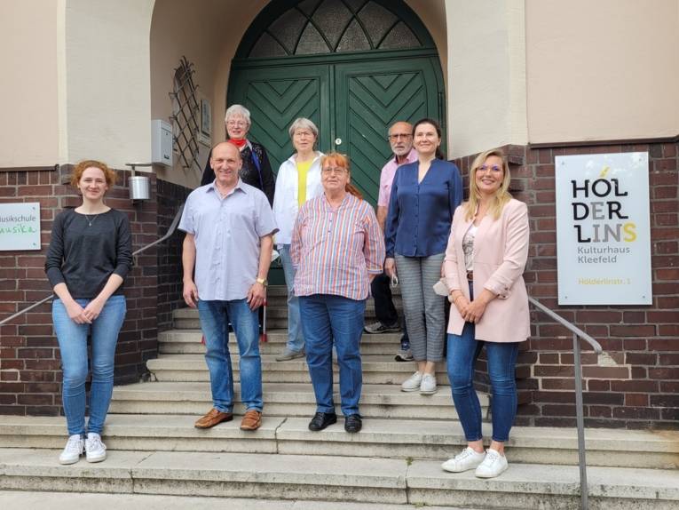 Damen und Herren stehen nebeneinander auf einer Treppe